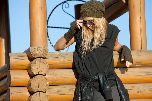 Beautiful blond standing near wooden well — Stock Photo, Image