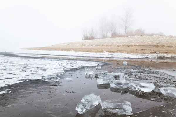 Hill in fog on a winter frozen river beach — Stock Photo, Image
