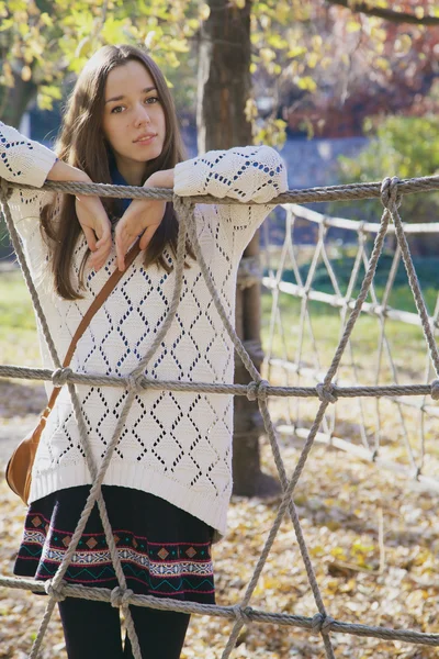Bela jovem adolescente posando perto de uma cerca de corda — Fotografia de Stock