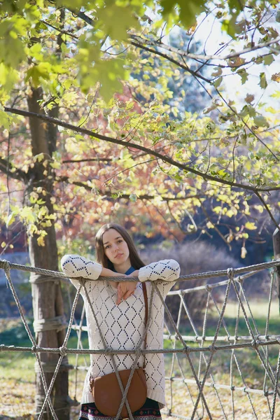 Hermosa joven adolescente posando cerca de una valla de cuerda — Foto de Stock