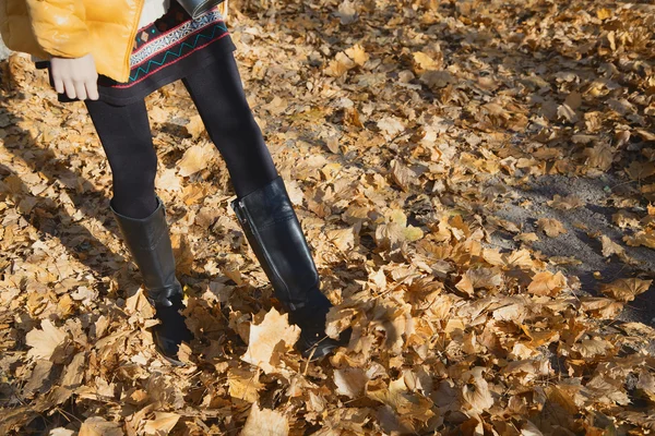 Sonbahar sarı yapraklar üzerinde yürüme düzgün kadın bacakları — Stok fotoğraf