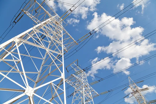 Linhas de transmissão de energia contra o céu azul — Fotografia de Stock