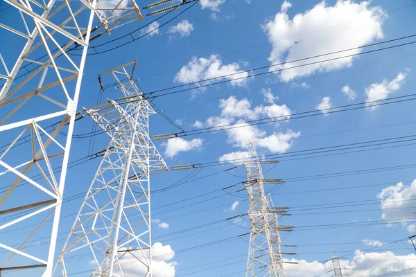 Linhas de transmissão de energia contra o céu azul — Fotografia de Stock