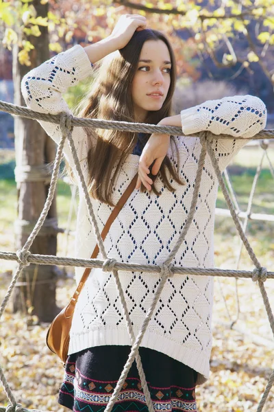 Beautiful young teenage girl posing near a rope fence — Stock Photo, Image