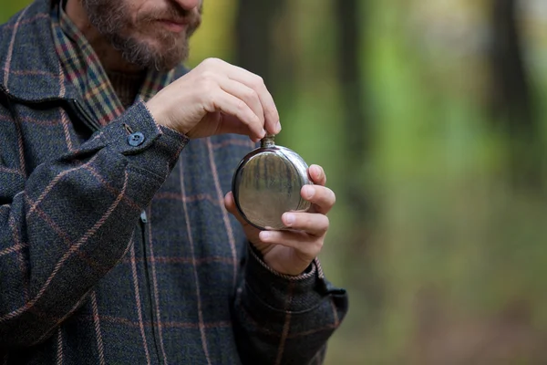 Man with beard opens the flask — Stock Photo, Image