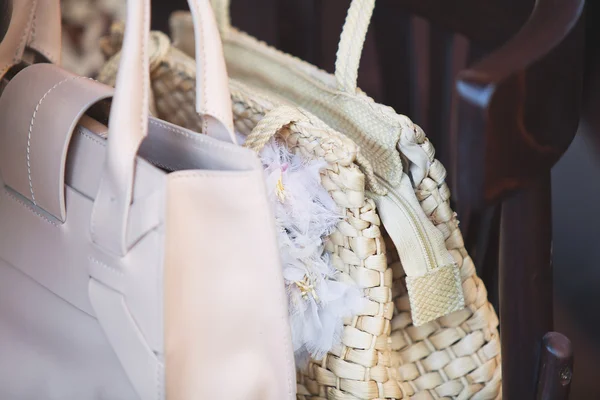 Bolsas femininas estão em uma cadeira marrom — Fotografia de Stock