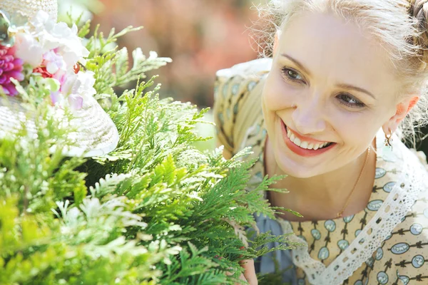 Jonge mooie vrouw verstopt achter een groene bush — Stockfoto