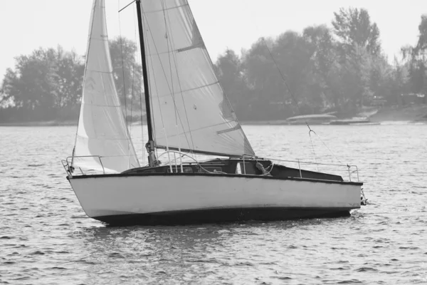 Monochrome picture of sailing yacht catching the wind by river b — Stock Photo, Image