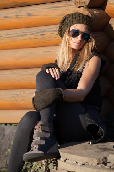 Stylish girl is sad near wooden well — Stock Photo, Image