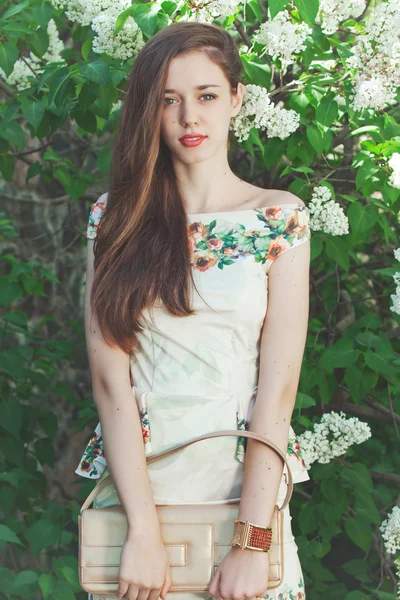 Belle jeune fille modèle posant près de fleurs lilas au printemps — Photo