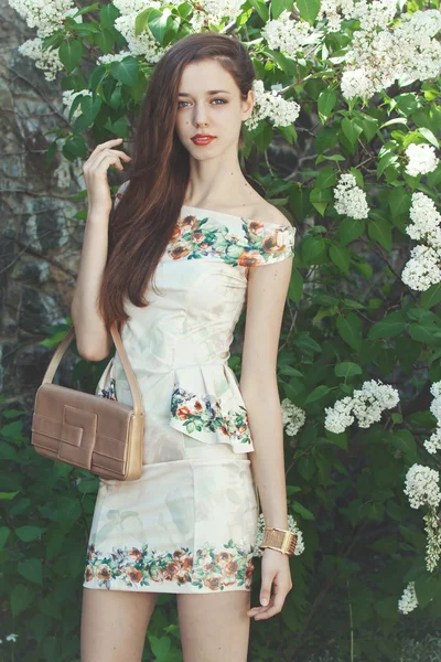 Modelo de menina bonita posando perto de lilases florescendo na primavera — Fotografia de Stock