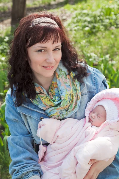 Ung mamma med nyfödda barn i utomhus på vår i Europa — Stockfoto