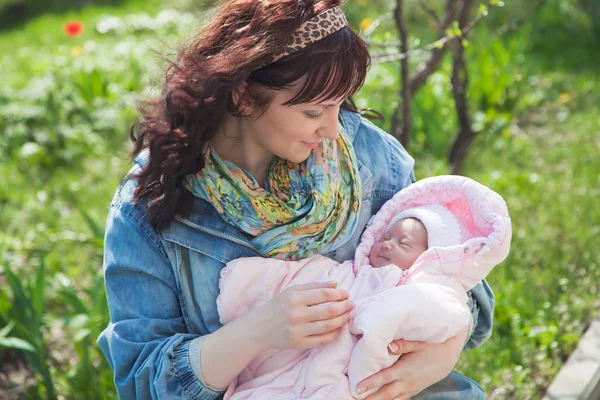 Молодая мама с новорожденным ребенком на открытом воздухе в весенний день — стоковое фото