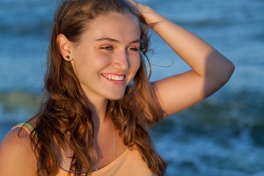 Yaz akşamında kumsalda kahverengi saçlı genç kız 