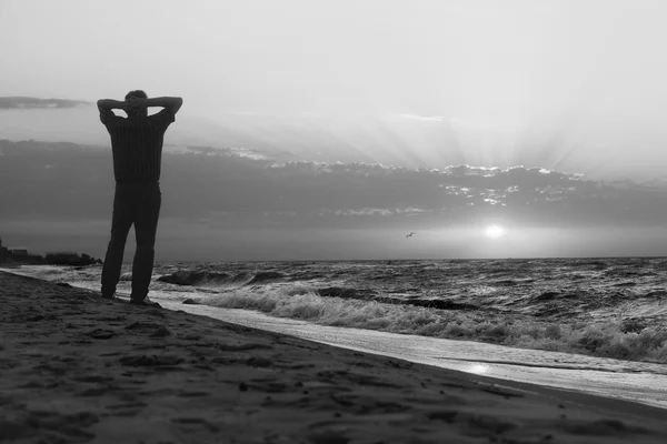 Immagine monocromatica dell'uomo all'alba sulla spiaggia — Foto Stock