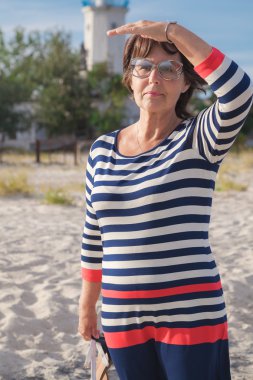 Yaşlı kadın deniz kıyısı mesafe bakarak