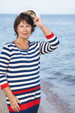 Sahilde deniz elbiseli oldukça memnun yaşlı kadın