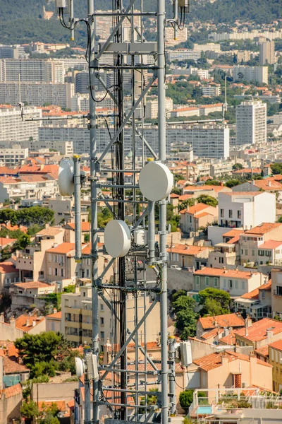 Воздушная антенна телекоммуникационной башни с городом позади — стоковое фото