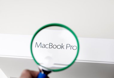 Büyüteç için Macbook Pro yüklü bakarak adam