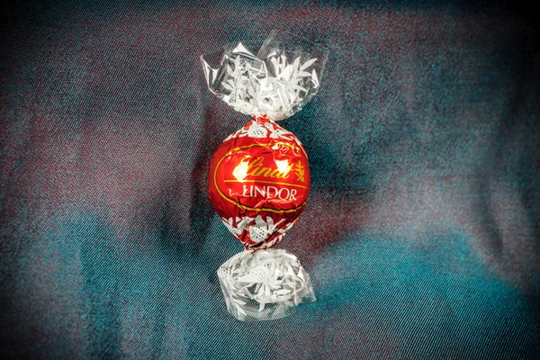 Lindt Lindor trufa de chocolate en un camaleón de lujo de seda backgr — Foto de Stock