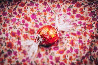 Kırmızı lüks çiçek arka plan üzerinde Lindt Lindor çikolatalı trüf