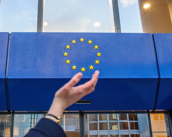 Manos de mujer tratando de sostener las estrellas de la insignia de la Unión Europea —  Fotos de Stock