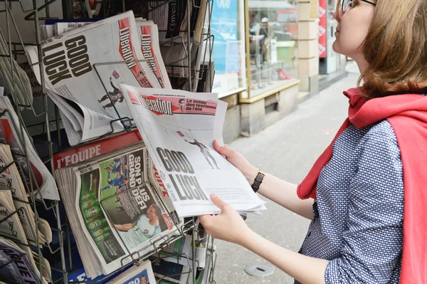 Žena, která kupuje noviny z osvobození se šokující titulek o — Stock fotografie
