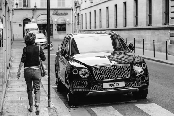 Mujer admirando el lujo Bentley Bentayga híbrido SUV — Foto de Stock