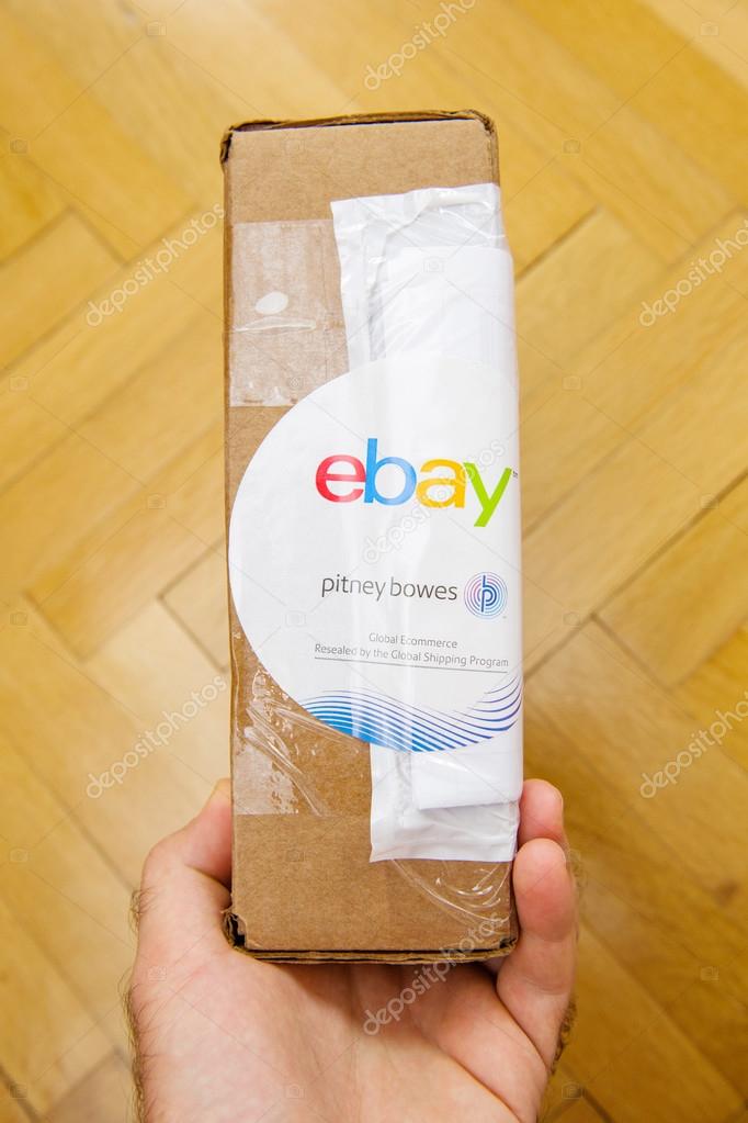 PARIS, FRANCE - JUN 8, 2016: Man hoding Ebay and Pitney Bowens box logotype printed on cardboard box security scotch tape of International Shipping Program.