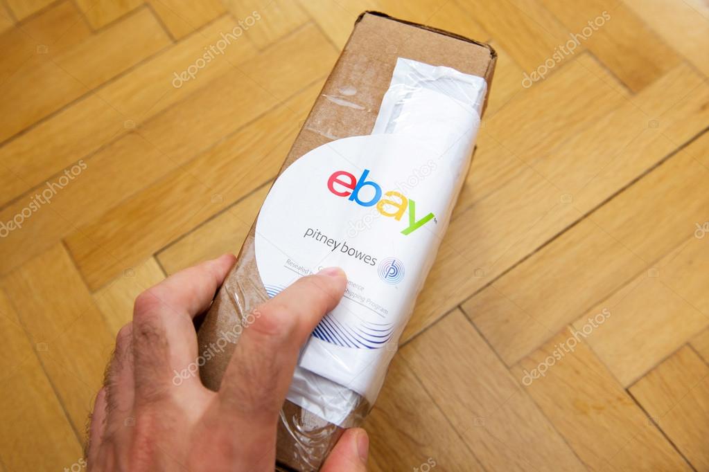 PARIS, FRANCE - JUN 8, 2016: Man hoding Ebay and Pitney Bowens box logotype printed on cardboard box security scotch tape of International Shipping Program.