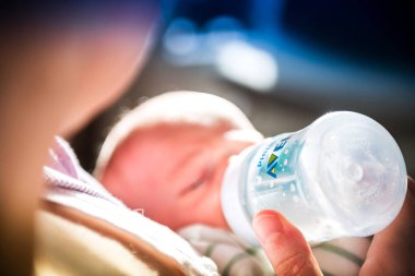 Philips Avent bebek şişesindeki bebeğe mama veren kadın.