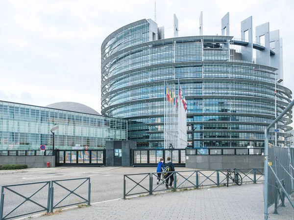 Boys on empty street wide view of European Parliament building with all flags — Stock Photo, Image