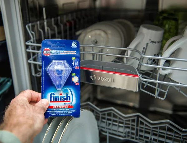 Мужская рука держит новый защитник отделки для посудомоечной машины — стоковое фото