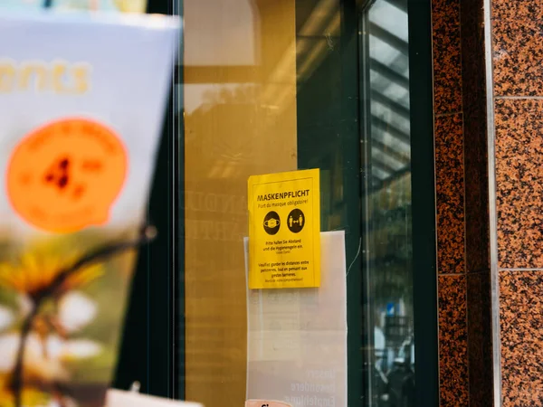 Entrada alemana a la tienda con texto en alemán diciendo por favor use su máscara — Foto de Stock