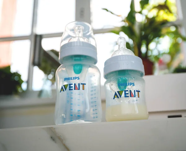 Dos biberones Philips Avent Natural uno con leche maternizada — Foto de Stock