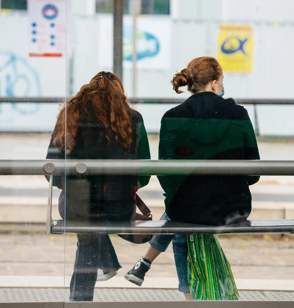 Chicas jóvenes con protección máscaras quirúrgicas esperando tranvía — Foto de Stock