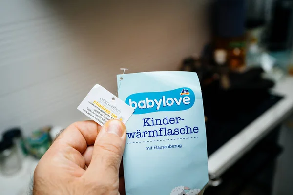 Man hand houden tegen kamer achtergrond nieuwe sticker van een Babylove — Stockfoto