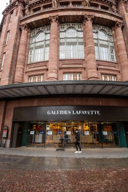 İkonik binanın önünde yürüyen bekâr bir adamla Lafayette 'in mağazasının düşük açılı görüntüsü.