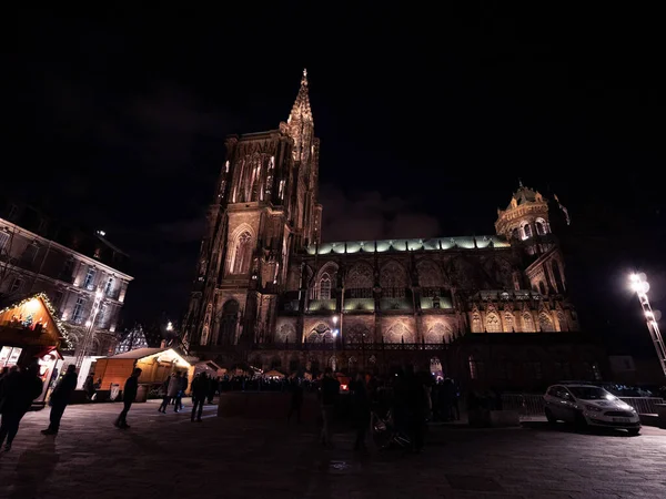 Vista de baixo ângulo da catedral de Notre-Dame com várias pessoas caminhando admirando o mercado de Natal — Fotografia de Stock