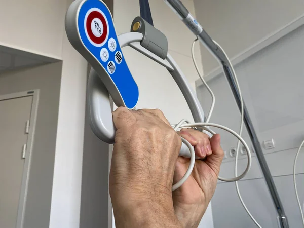 Mão macho sênior segurando o pólo de elevação do paciente com alça de pega e botões de sinal para chamada de enfermeira — Fotografia de Stock