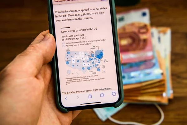 POV мужчина рука держит iPhone с коронавирусом подтвердил случаи в США — стоковое фото
