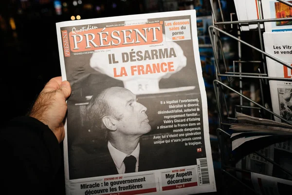 POV mano masculina sosteniendo periódico Quotidien Present en quiosco de prensa francés — Foto de Stock