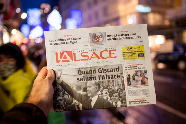 Homem segurando jornal francês LAlsace no quiosque de imprensa anunciando a morte de Valery Giscard dEstaing — Fotografia de Stock