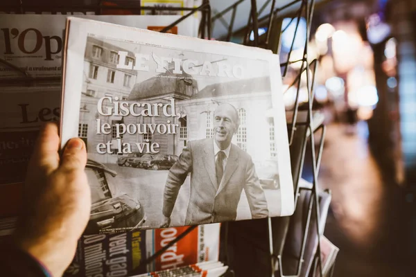 Man holding Le Figaro newspaper at French press kiosk announcing the death of Valery Giscard dEstaing — Stock Photo, Image