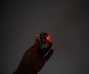 Erkek el, gelecekteki güvenli ev lazeri lazer ışınlayıcı güvenlik alarmı. Davetsiz misafirleri ve hırsızları tespit etmek için kırmızı lazer ışığı kullanılıyor.