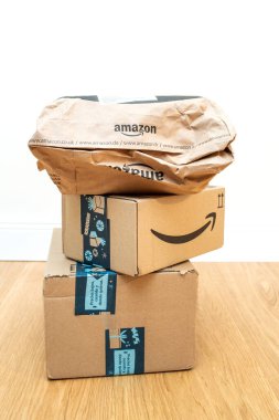İki adet dikdörtgen karton paket ve içinde Noel tatili boyunca hediyeler olan Amazon ana logosu olan bir kese kağıdı.