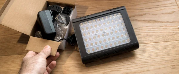 POV Man hand packa upp nya Manfrotto LED Light Lykos 2.0, 2 i 1 vattentät med Bluetooth — Stockfoto