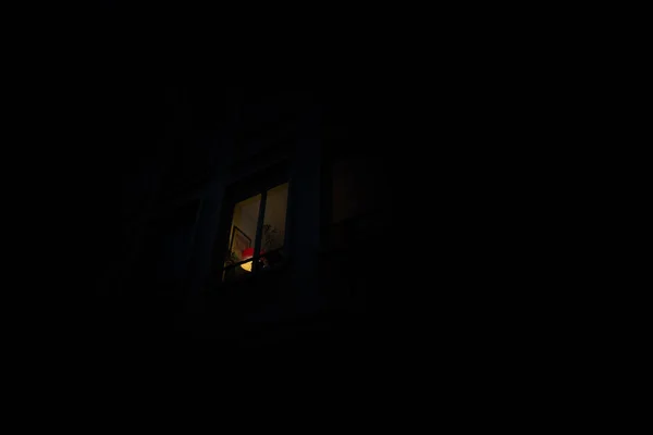 Blick von der Straße auf ein einsames helles Fenster mit einem Licht am — Stockfoto