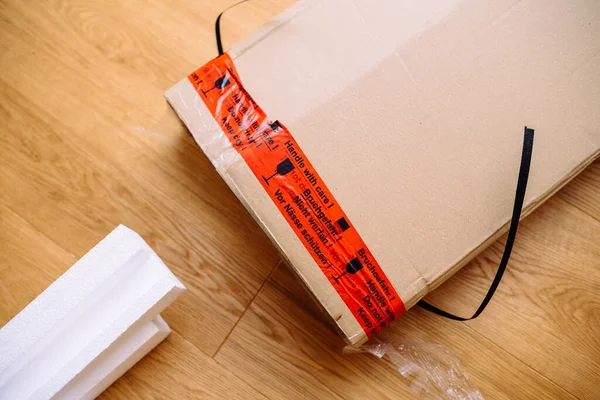Caja de cartón con inscripción Manija con cuidado en varios idiomas - paquetes frágiles mercancías transportadas por correo —  Fotos de Stock