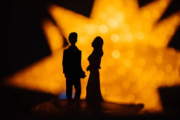 Όμορφη νύφη ζευγάρι και γαμπρός σιλουέτα με φωτεινό κίτρινο αστέρι διακοπών στο παρασκήνιο — Φωτογραφία Αρχείου